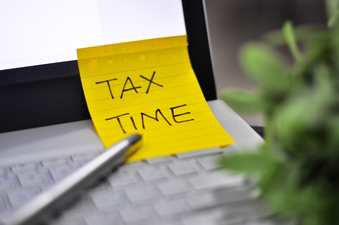Tax Season: 1040 U.S. Individual Income Tax Return Form Horizontal top right view of an office laptop background with a metallic pen Tax Time note pad reminder green tree foregrounds - work from home and personal and social distancing - copy space digitally generated image